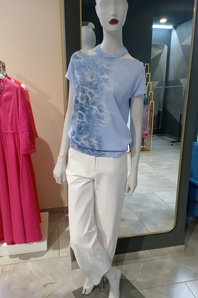 Фото из магазина Emporio: голубая футболка, белые брюки и сумка на манекене в зале